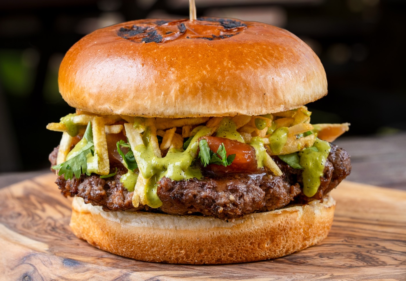 Amazing Lomo Saltado Burger topped with crunchy potatoes and aji verde
